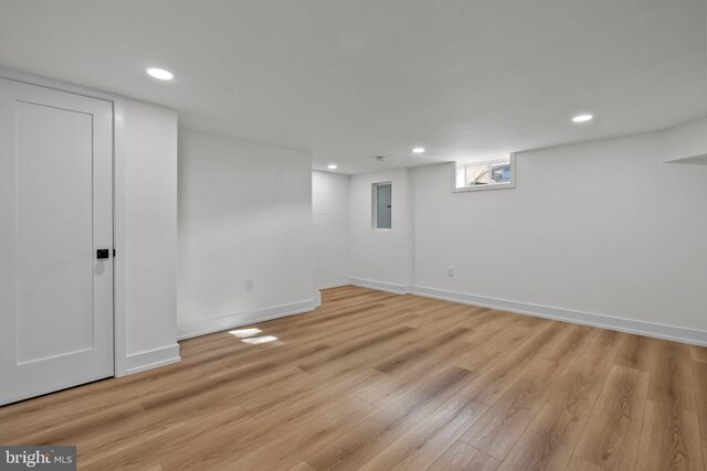 basement with electric panel and light wood-type flooring