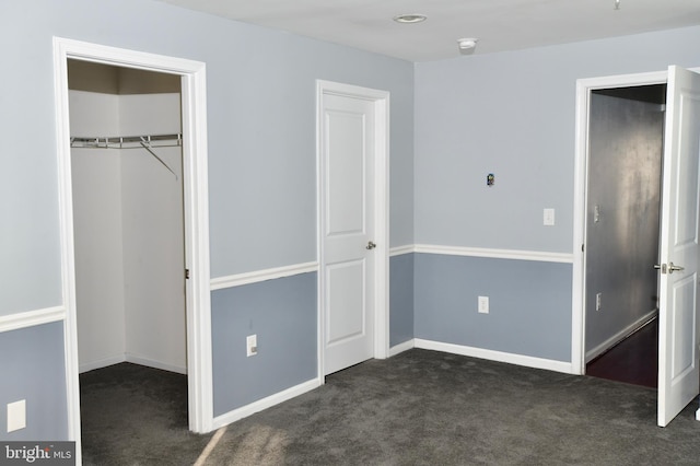 unfurnished bedroom with dark colored carpet and a closet