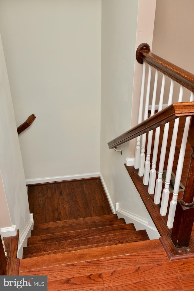 staircase with hardwood / wood-style floors