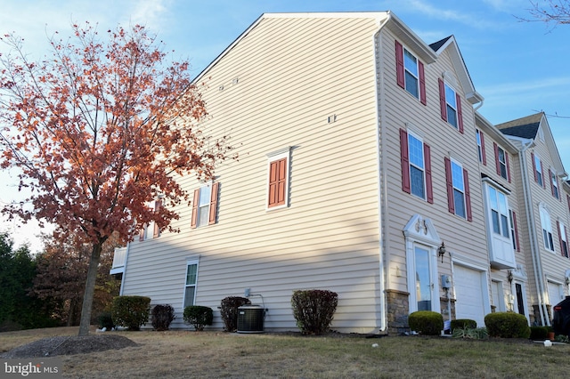 view of home's exterior with cooling unit and a garage