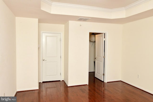 unfurnished bedroom featuring crown molding, dark wood-type flooring, and a closet