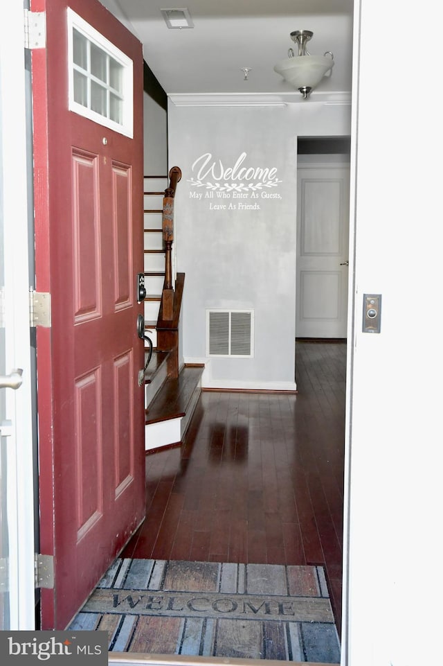 entryway featuring dark wood-type flooring and ornamental molding