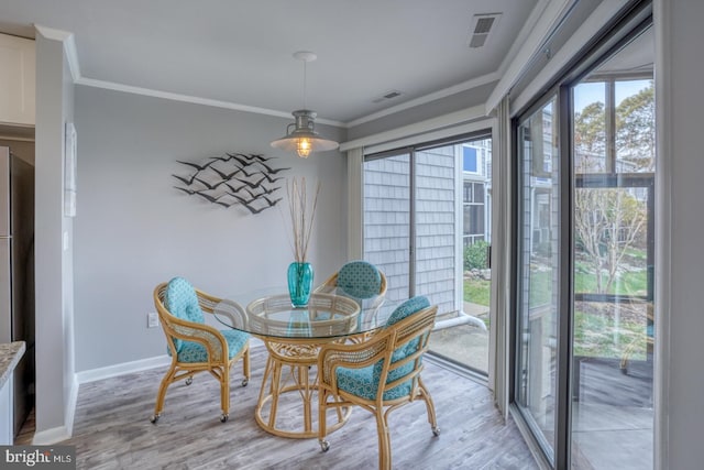 dining area featuring light hardwood / wood-style flooring and ornamental molding