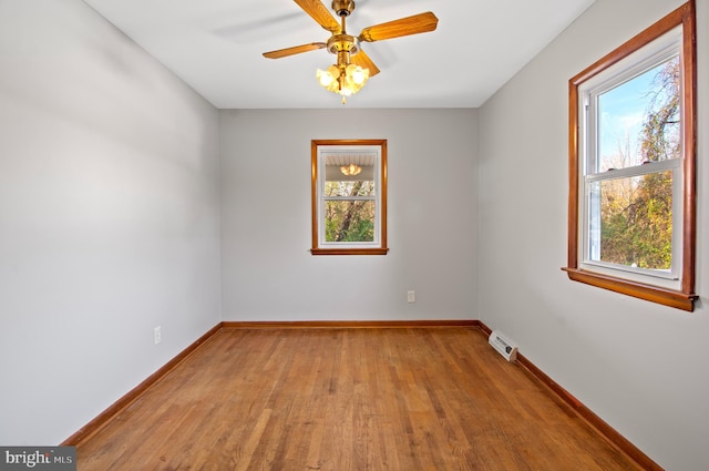 empty room with ceiling fan, plenty of natural light, and light hardwood / wood-style floors