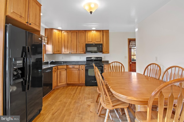 kitchen with sink, black appliances, and light wood-type flooring