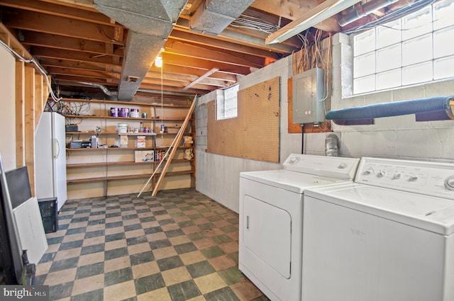 clothes washing area featuring electric panel and washer and clothes dryer