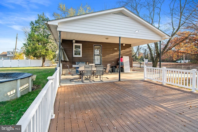 deck with a covered pool, a patio area, and a lawn