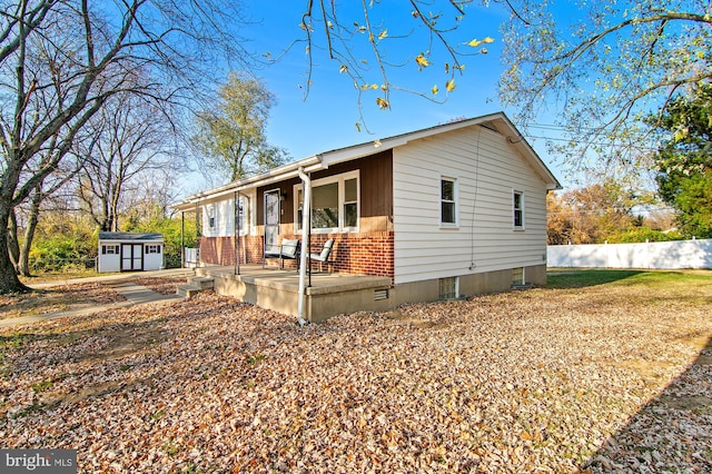 view of front of house with covered porch and a shed