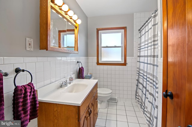 bathroom with tile patterned floors, walk in shower, vanity, tile walls, and toilet