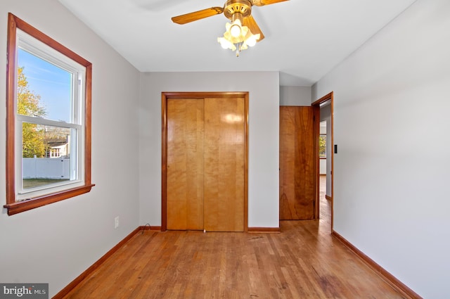 unfurnished bedroom with ceiling fan, a closet, and light wood-type flooring