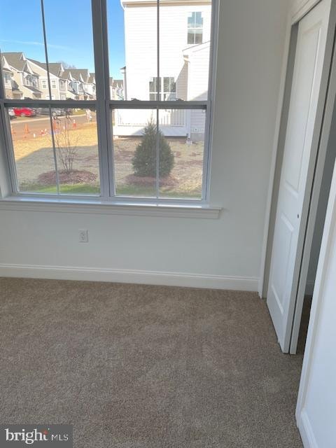 carpeted empty room featuring a wealth of natural light