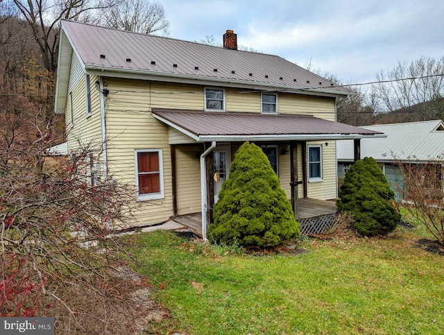 rear view of house featuring a yard