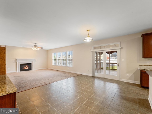 unfurnished living room with light tile patterned floors and ceiling fan