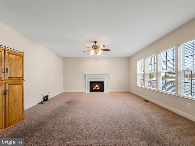 unfurnished living room featuring carpet and ceiling fan