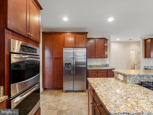 kitchen featuring light stone counters, light tile patterned floors, and stainless steel appliances