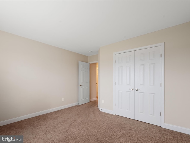 unfurnished bedroom with carpet floors and a closet