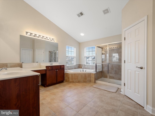 bathroom featuring tile patterned flooring, vanity, independent shower and bath, and vaulted ceiling