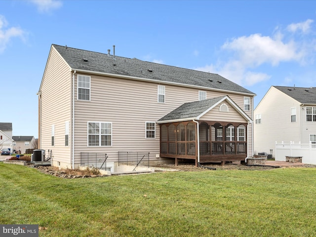 rear view of property with central AC, a sunroom, and a yard