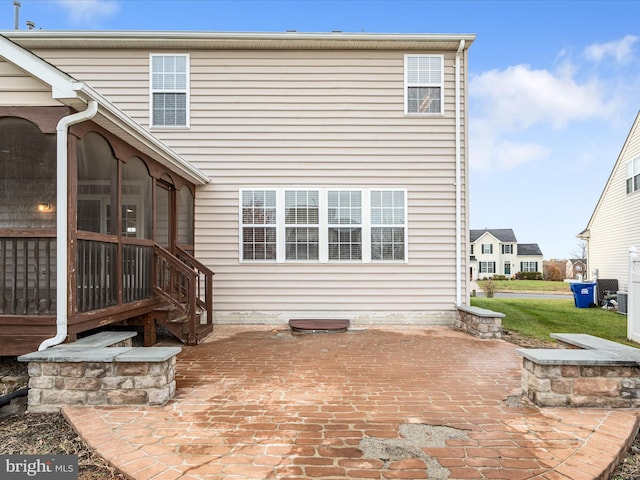 rear view of property featuring a sunroom and a patio area