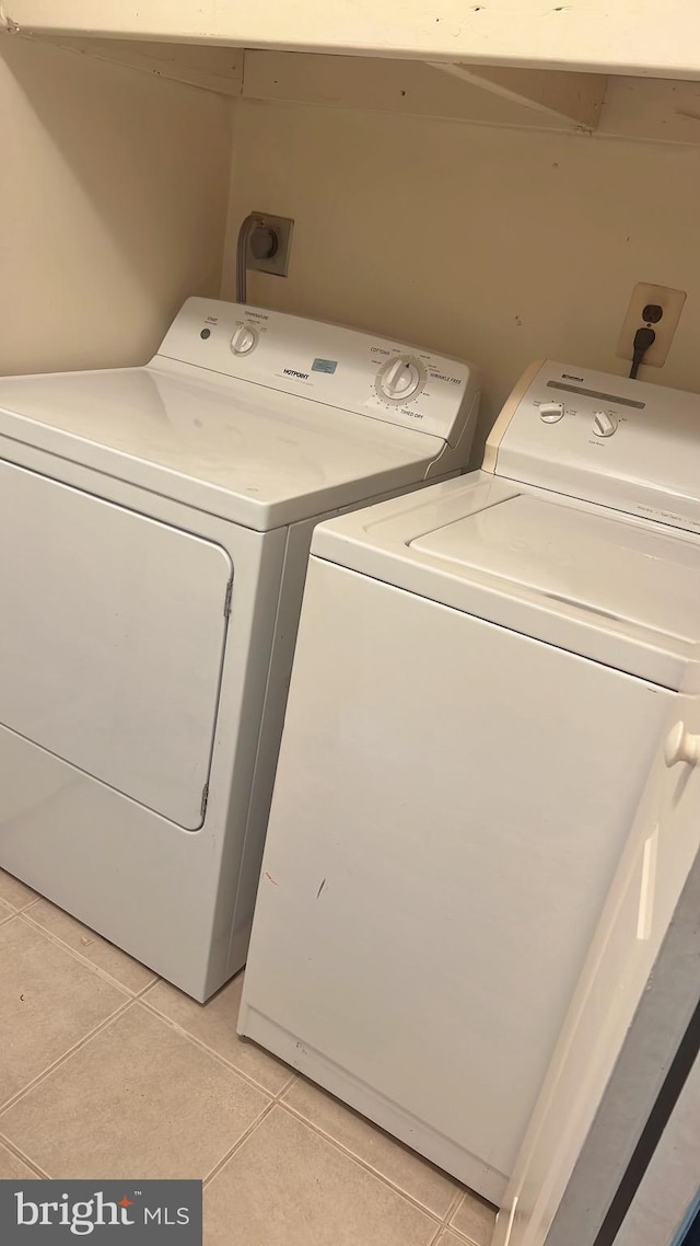 laundry area with light tile patterned flooring and washer and dryer