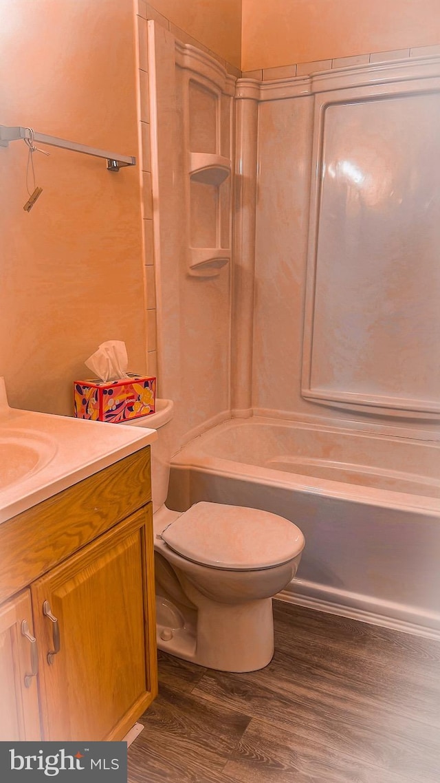 full bathroom with washtub / shower combination, hardwood / wood-style floors, vanity, and toilet