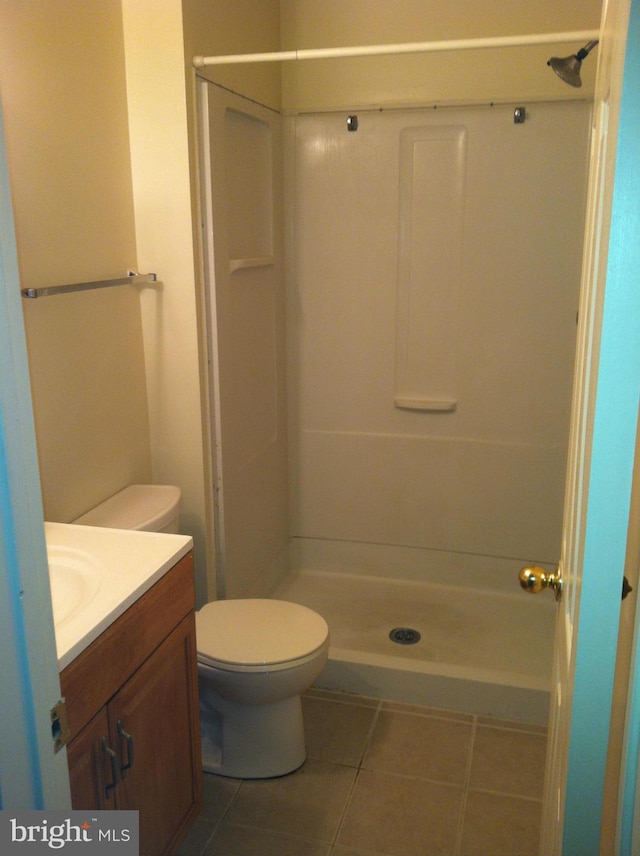 bathroom featuring a shower, tile patterned flooring, vanity, and toilet