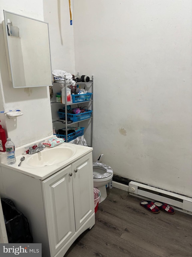 bathroom featuring hardwood / wood-style floors, vanity, toilet, and a baseboard radiator