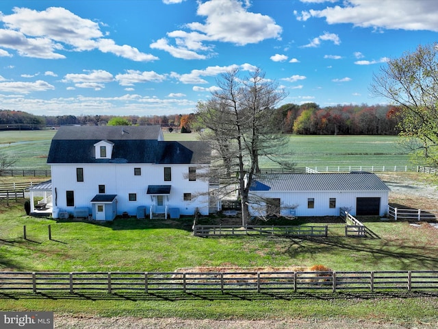 exterior space with an outbuilding, a rural view, and a front lawn