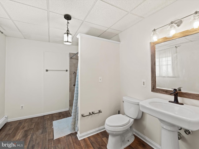 bathroom with sink, a paneled ceiling, hardwood / wood-style floors, a shower with curtain, and toilet