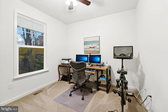 carpeted home office featuring ceiling fan