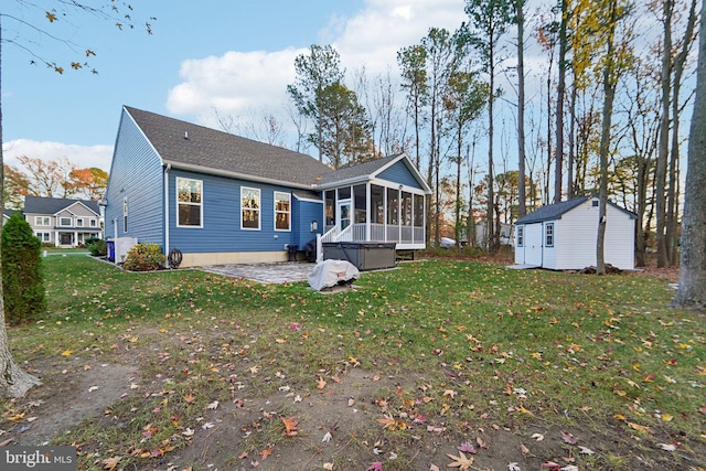 back of house with a sunroom, a storage unit, and a lawn