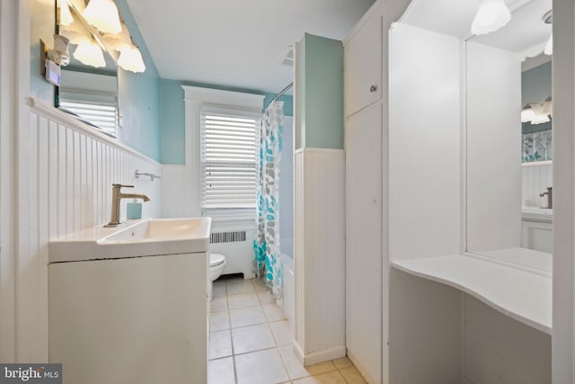 full bathroom with radiator, tile patterned flooring, toilet, vanity, and shower / tub combo