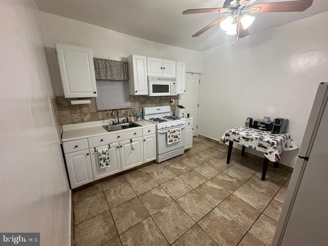 kitchen with tasteful backsplash, white appliances, ceiling fan, sink, and white cabinets