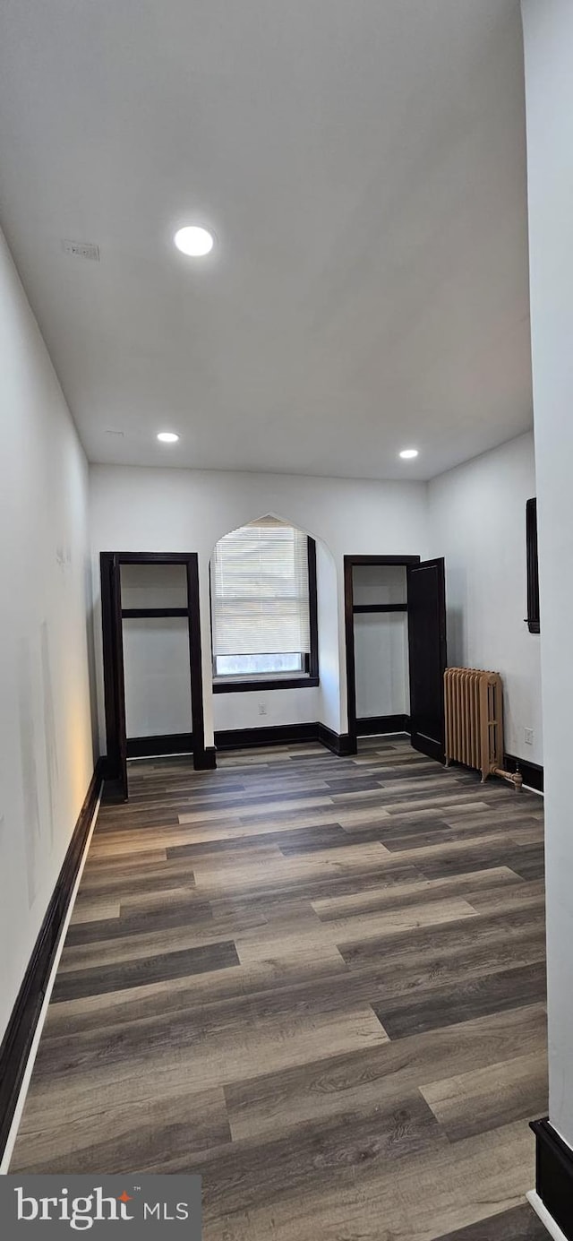 hall featuring dark wood-type flooring and radiator