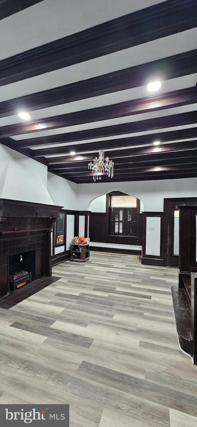 interior space featuring light hardwood / wood-style floors, a high end fireplace, and beam ceiling