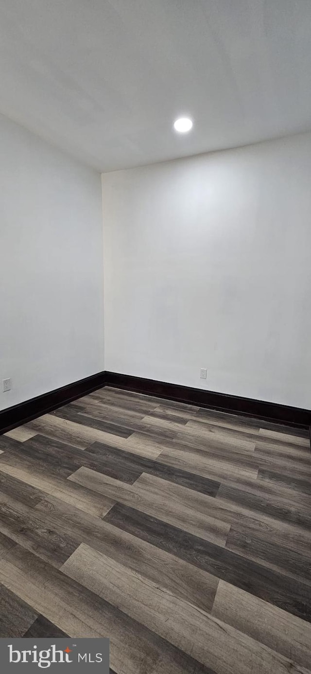 empty room with dark hardwood / wood-style flooring