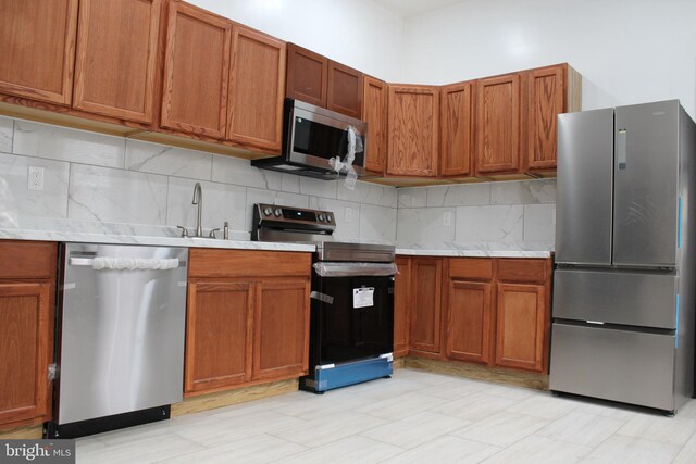 kitchen with sink, stainless steel appliances, and tasteful backsplash