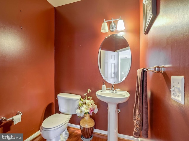 bathroom with hardwood / wood-style flooring and toilet