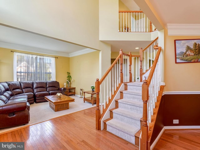 living room with light wood-type flooring and ornamental molding