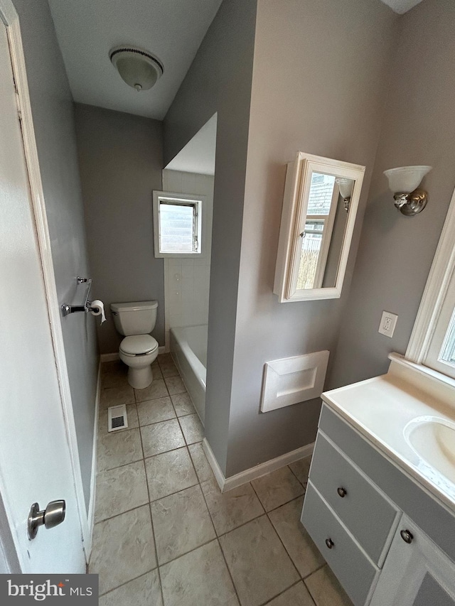 bathroom with a bathing tub, tile patterned flooring, vanity, and toilet