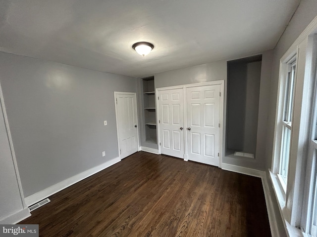 unfurnished bedroom with dark hardwood / wood-style flooring