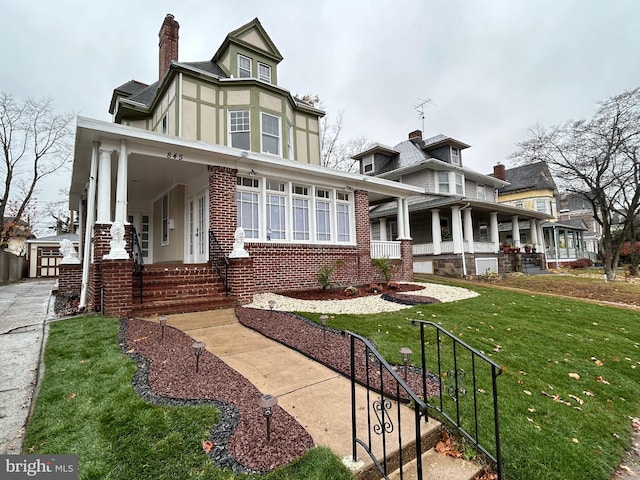 exterior space featuring covered porch and a front yard