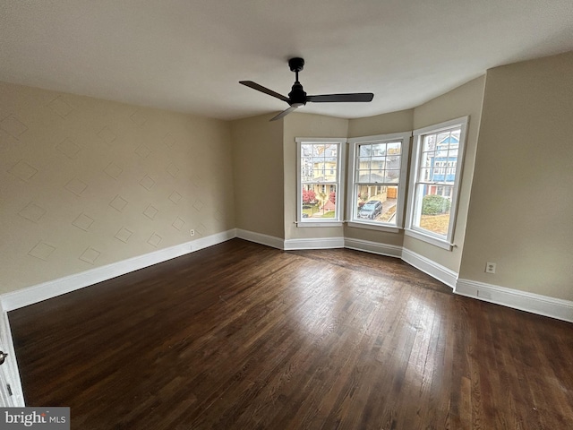 spare room with dark hardwood / wood-style floors and ceiling fan