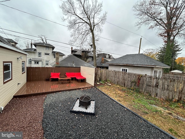 view of yard featuring an outdoor living space with a fire pit and a deck