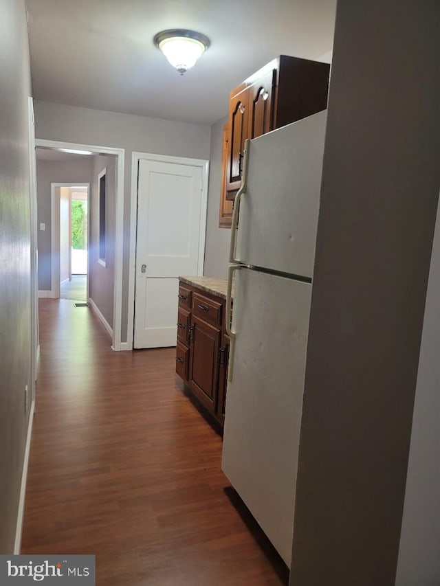 kitchen with white fridge and dark hardwood / wood-style floors