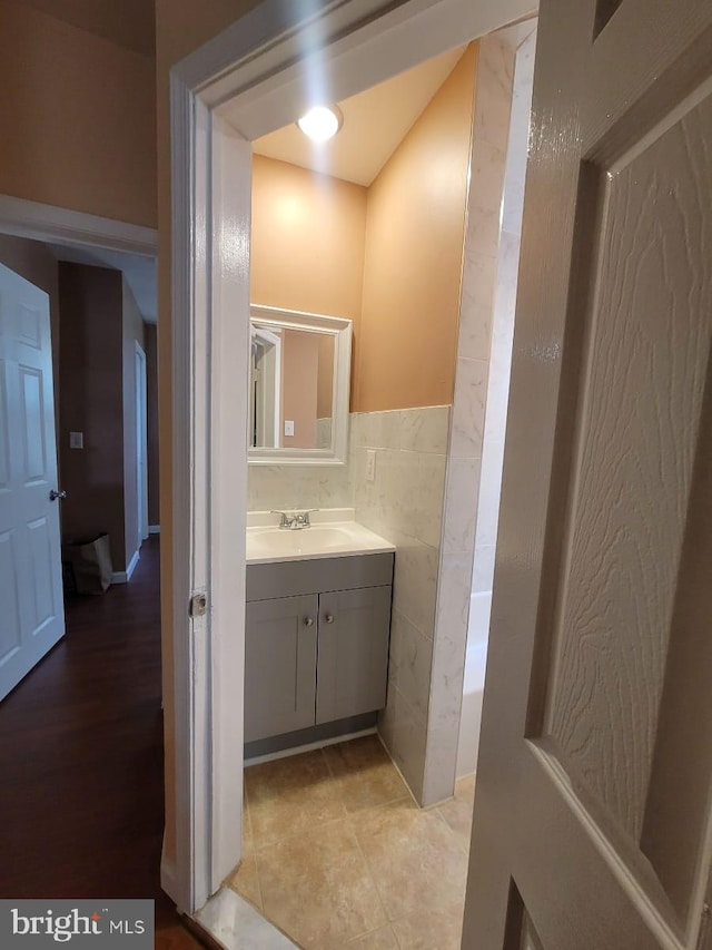 bathroom featuring vanity, tile patterned floors, and tile walls