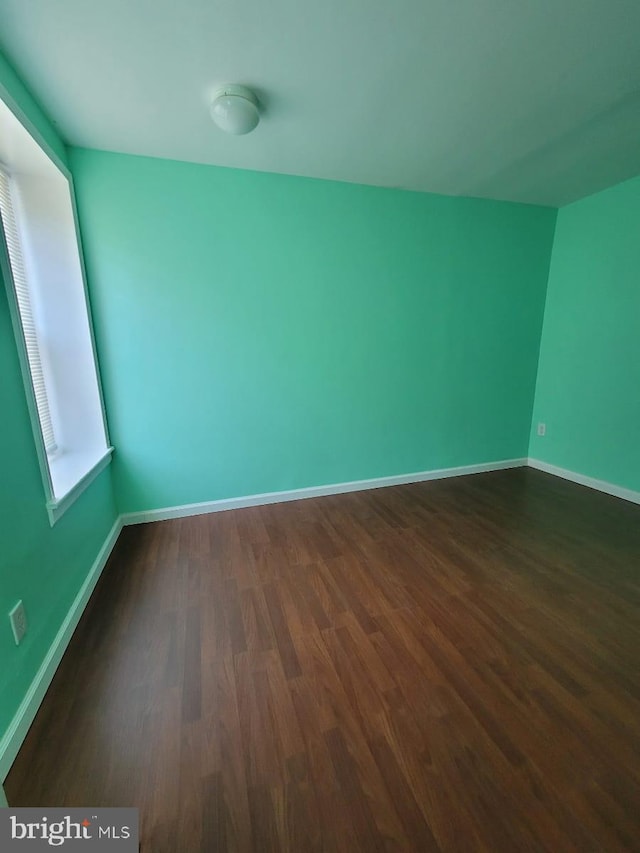 unfurnished room featuring dark wood-type flooring