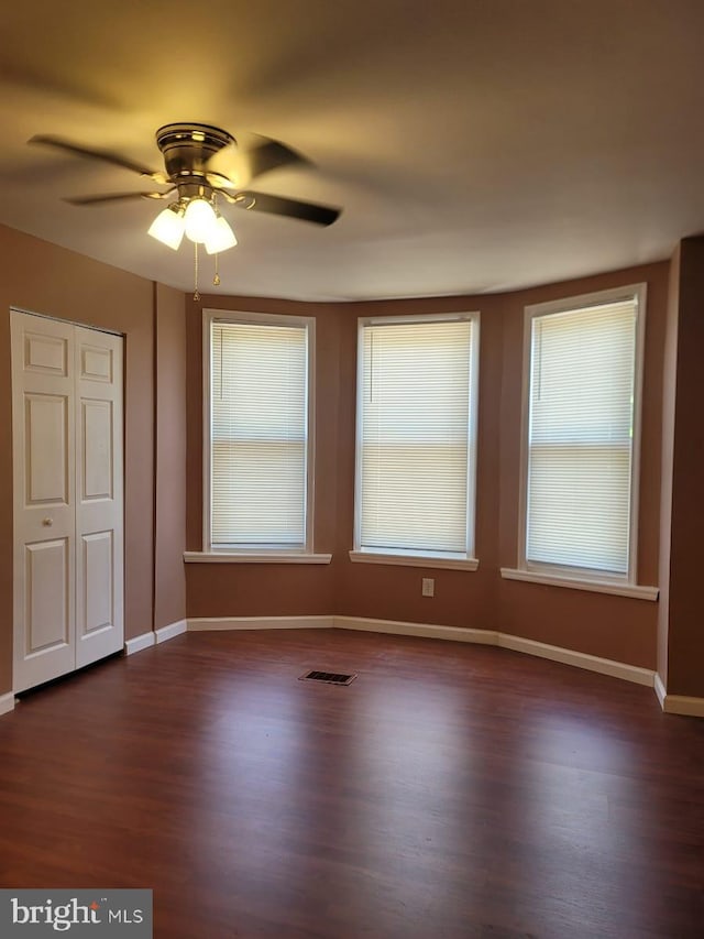 spare room with ceiling fan and dark hardwood / wood-style flooring