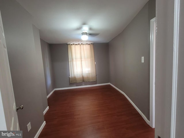 unfurnished room with ceiling fan and dark wood-type flooring