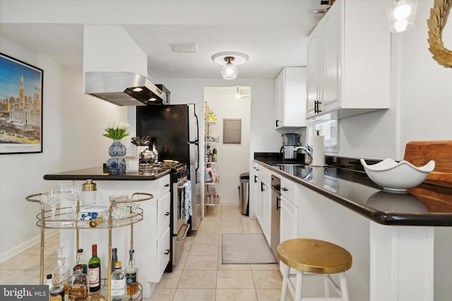 kitchen with white cabinets, kitchen peninsula, a breakfast bar area, and exhaust hood